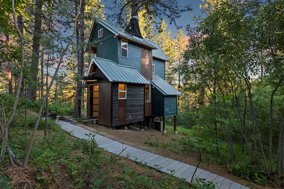 Banks Treehouse exterior, front view at sunset among Ponderosa pines
