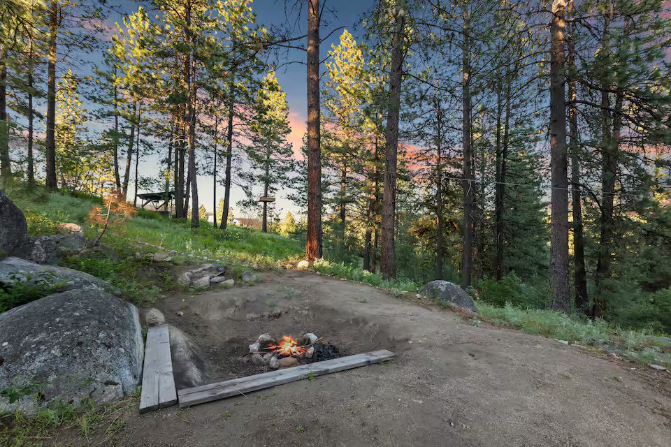 Fire pit area at sunset among Ponderosa pines on the Banks Treehouse property