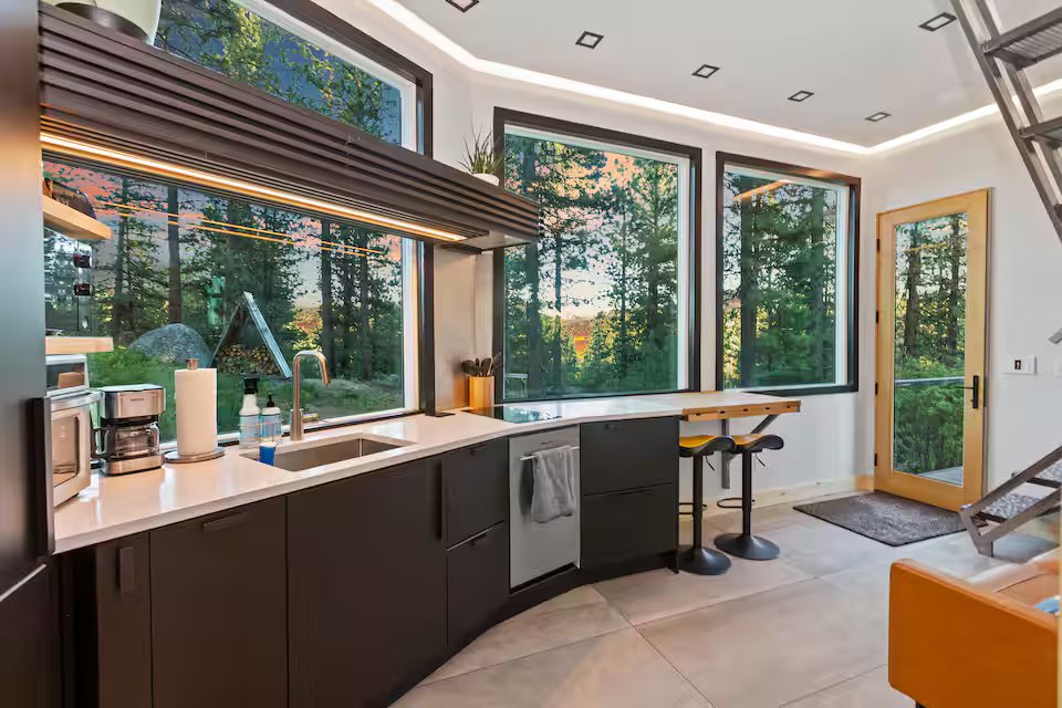 Kitchen with large panoramic windows looking into the forest