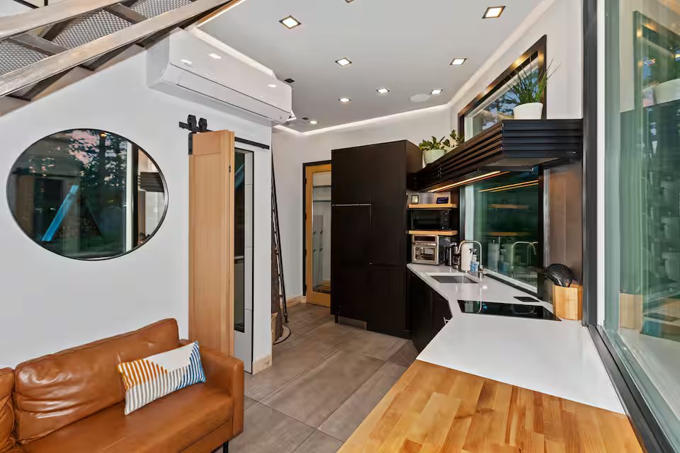 Living area with round window, barn door, and kitchen overview